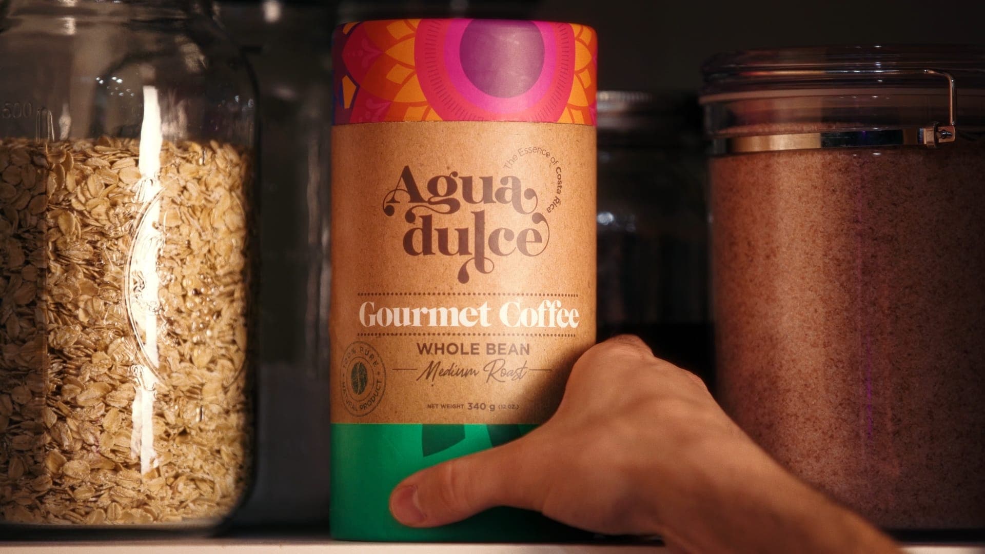 hand reaching for an agua dulce coffee tin on a pantry shelf